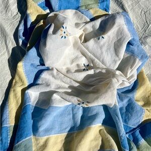 White and blue vintage hand-embroidered tablecloth with yellow and blue floral